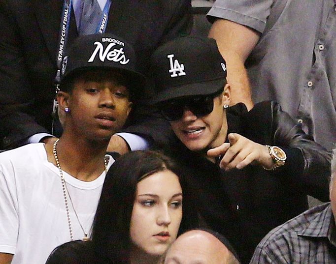 Singer Justin Bieber (R) sits in the crowd as he attends Game 7 of the Western Conference semi-final hockey playoff between the Los Angeles Kings and the San Jose Sharks