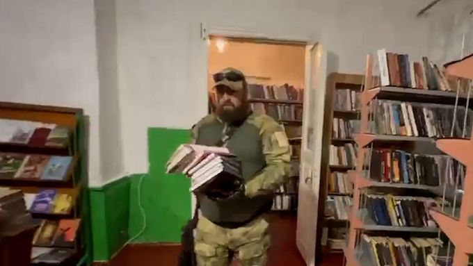 Ozbrojení Rusové se točili v okupovaném Melitopolu, jak odstraňují v knihovně „závadné“ knihy.