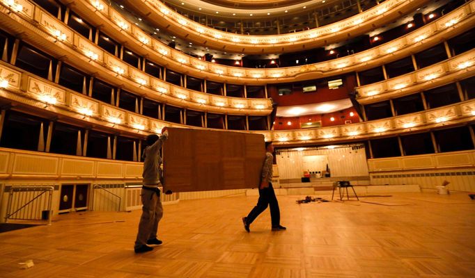 Workers carry a part of the dance floor in the opera house in Vienna