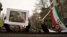 Provládní demonstranti v Teheránu s vlajkou a obrázkem ajatoláha Chameneího.