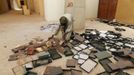 A museum guard picks up boxes holding ancient manuscripts, which were partially damaged by Islamist rebels, at the Ahmed Baba Institute, or Ahmed Baba Centre for Documentation and Research, in Timbuktu January 31, 2013. The majority of Timbuktu's ancient manuscripts appear to be safe and undamaged after the Saharan city's 10-month occupation by Islamist rebel fighters, experts said on Wednesday, rejecting some media reports of their widespread destruction. REUTERS/Benoit Tessier (MALI - Tags: POLITICS CIVIL UNREST CONFLICT SOCIETY) Published: Led. 31, 2013, 8:04 odp.