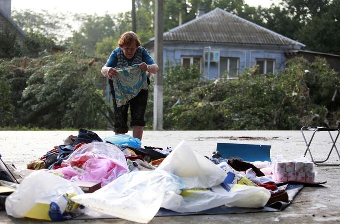 A local resident lays out her belongings on the ground in the town of Krymsk, seriously damaged by floods, in Krasnodar region, southern Russia, July 8, 2012. Russian President Vladimir Putin ordered investigators to find out if enough was done to prevent 144 people being killed in floods in southern Russia after flying to the region to deal with the first big disaster of his new presidency. REUTERS/Eduard Korniyenko (RUSSIA - Tags: DISASTER ENVIRONMENT POLITICS) Published: Čec. 8, 2012, 7:52 dop.