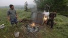 A man dodges after lighting firecrackers in front of the tomb of his friend's (L) father, who died during Saturday's earthquake in Lushan county, Ya'an, Sichuan province, April 23, 2013. Burning firecrackers during a burial for relatives is believed to dispel evil spirits away from the dead, in some parts of China. Picture taken April 23, 2013. REUTERS/Stringer (CHINA - Tags: DISASTER SOCIETY OBITUARY) CHINA OUT. NO COMMERCIAL OR EDITORIAL SALES IN CHINA Published: Dub. 24, 2013, 4:49 dop.