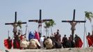 Ruben Enaje (C), 52, who is portraying Jesus Christ for the 27th time, hangs on a cross beside two men, who portray Dismas and Gestas, after he was nailed to it during a Good Friday crucifixion re-enactment in San Pedro Cutud town, Pampanga province, north of Manila March 29, 2013. The Roman Catholic church frowns on the gory spectacle held in the Philippine village of Cutud every Good Friday but does nothing to deter the faithful from emulating the suffering of Christ and taking a painful route to penitence. Holy Week is celebrated in many Christian traditions during the week before Easter. REUTERS/Romeo Ranoco (PHILIPPINES - Tags: RELIGION SOCIETY) Published: Bře. 29, 2013, 7:54 dop.