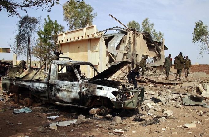 Malian soldiers walk past a destroyed vehicle, which according to Malian soldiers, belonged to Islamist rebels at the prefecture of the recently liberated town of Konna January 26, 2013. REUTERS/Eric Gaillard (MALI - Tags: CIVIL UNREST CONFLICT MILITARY) Published: Led. 26, 2013, 2:20 odp.