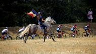 Trať staré dámy je fanoušky doslova obsypána. A nemusí být jen "opěšalí", s cyklisty si na dálku poměřila síly jezdkyně na koni s francouzskou vlajkou