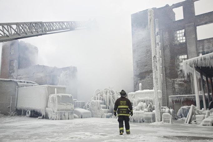 Chicago Fire Department Lieutenant Charley De Jesus walks around an ice-covered warehouse that caught fire Tuesday night in Chicago January 23, 2013. Fire department officials said it is the biggest fire the department has had to battle in years and one-third of all Chicago firefighters were on the scene at one point or another trying to put out the flames. An Arctic blast continues to gripped the U.S. Midwest and Northeast Wednesday, with at least three deaths linked to the frigid weather, and fierce winds made some locations feel as cold as 50 degrees below zero Fahrenheit. (minus 46 degrees Celsius) REUTERS/John Gress (UNITED STATES - Tags: DISASTER ENVIRONMENT) Published: Led. 23, 2013, 6:01 odp.