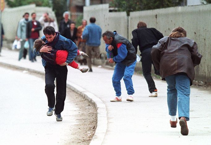 Bosenský muž s dítětem v náručí s ostatními chodci utíká před ostřelovačem, Sarajevo, duben 1993.