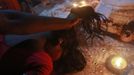 A man holds a devotee who is believed to be possessed by evil spirits by her hair while confronting her as she goes into a state of trance while lying on a sacred platform at Guru Deoji Maharaj temple during a ghost fair at Malajpur village in Betul district in the central Indian state of Madhya Pradesh January 26, 2013. People from across India come to this fair to be exorcised of �evil spirits�. They are usually brought by relatives and they are most often women. The exorcism involves running around the temple courtyard to make the 'ghost' weak then being beaten by a priest with a broom. Picture taken January 26, 2013. REUTERS/Danish Siddiqui (INDIA - Tags: SOCIETY RELIGION) ATTENTION EDITORS: PICTURE 21 OF 24 FOR PACKAGE 'INDIAN GHOSTBUSTERS' SEARCH 'INDIA GHOST' FOR ALL IMAGES Published: Úno. 5, 2013, 5:10 dop.