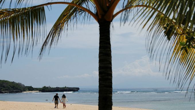 Pár se prochází na pláži Nusa Dua na Bali.