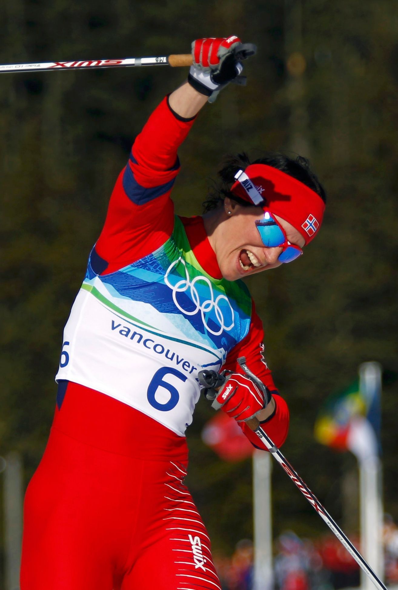 Marit Björgenová vbíhá s vítězným gestem do cíle