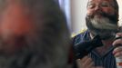 German hairdresser Elmar Weisser, 48, is reflected in a mirror in his hotel room as he starts shaping his beard as a stork to compete in the 2012 European Beard and Moustache Championships in Wittersdorf near Mulhouse, Eastern France, September 22, 2012. Weisser, who won the World Beard and Moustache Championship in 2011, ranked second in the freestyle category of the European championships on Saturday. Picture taken September 22, 2012. REUTERS/Vincent Kessler (FRANCE - Tags: SOCIETY) Published: Zář. 23, 2012, 11:54 dop.