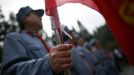 A mid-level government official dressed in a red army uniform holds a flag as he visits an old house where former Chinese leader Mao Zedong use to lived, during a five-day training course at the communist party school called China Executive Leadership Academy of Jinggangshan, in Jiangxi province September 21, 2012. China Executive Leadership Academy was established in 2005 by the Central Committee of the Communist Party of China, after the 16th Communist Party Congress in 2002. By the end of August 2012, the academy has held 789 training classes for almost 40,000 people. During the course, trainees listen and sing revolutionary songs, visit old revolutionary sites and review historical communist materials. China has yet to announce the starting date for the 18th Communist Party Congress, China's biggest political meeting in a decade, which will see the transfer of power from President Hu Jintao and Premier Wen Jiabao to a new generation. REUTERS/Carlos Barria (CHINA - Tags: POLITICS SOCIETY) Published: Zář. 21, 2012, 3:38 odp.