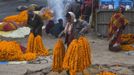 A vendor carries garlands of marigold flowers to sell along the banks of the Ganges river ahead of the "Kumbh Mela" (Pitcher Festival), in the northern Indian city of Allahabad January 11, 2013. During the festival, Hindus take part in a religious gathering on the banks of the river Ganges. "Kumbh Mela" will return to Allahabad in 12 years. REUTERS/Ahmad Masood (INDIA - Tags: RELIGION) Published: Led. 11, 2013, 10:21 dop.