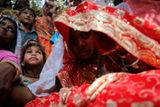 Dětská nevěsta Krishna ve svůj velký den oblékla červené sárí.