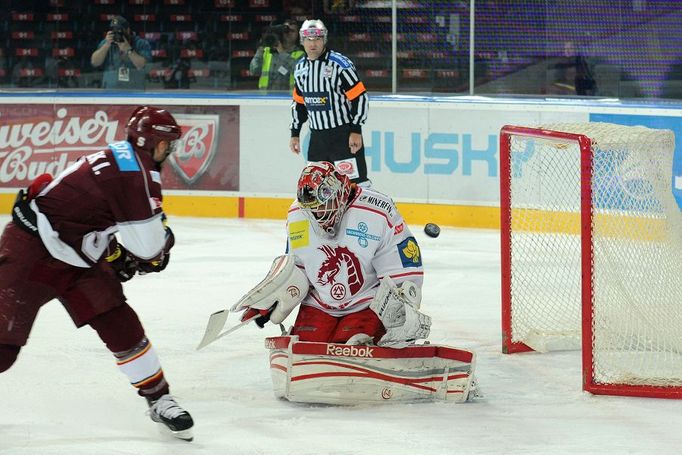 Hokejista pražské Sparty Ivan Rachůnek střílí na Šimona Hrubce v utkání 6. kola Tipsport extraligy 2012/13 s Oceláři Třinec.