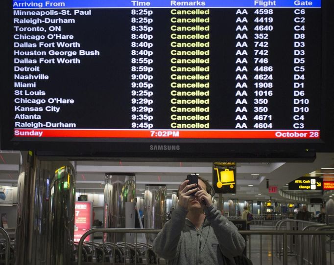 A traveller takes pictures of a flight monitor showing cancelled flights at LaGuardia airport in New York October 28, 2012. Tens of millions of East Coast residents scrambled on Sunday to prepare for Hurricane Sandy, which could make landfall as the largest storm to hit the United States, bringing battering winds, flooding and even heavy snow. REUTERS/Adrees Latif (UNITED STATES - Tags: TRANSPORT DISASTER ENVIRONMENT)