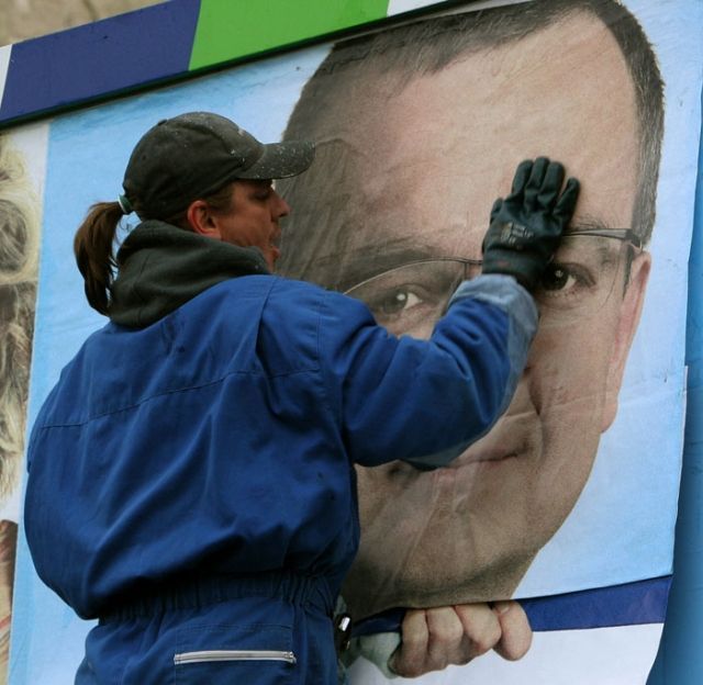 Pracovník firmy Europlakát připevňuje na reklamní plochu v pražské Libni billboard, kterým chce voliče zaujmout KDU-ČSL
