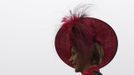 A woman poses in her hat on Ladies Day, the second day of racing at the Cheltenham Festival horse racing meet in Gloucestershire, western England March 14.