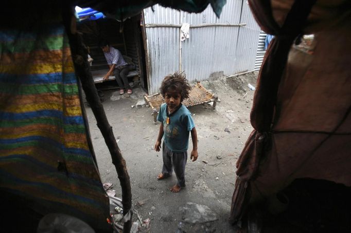 Shivani Choudhary, 7, a street performer, stands in front of her hut in a slum on the bank of Manahara River before leaving to perform on the streets of Kathmandu August 15, 2012. Shivani and her brothers Drumpal and Gchan, who came to Kathmandu from India 5 years ago, earn their living by performing tricks on the streets of Kathmandu. According to Drumpal, Shivani's older brother, they earn around $10 a day by performing tricks, which is not enough to feed their 10-member family living together in a small hut without a proper toilet or any basic needs. REUTERS/Navesh Chitrakar (NEPAL - Tags: SOCIETY IMMIGRATION POVERTY) Published: Srp. 15, 2012, 3:59 odp.