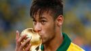 Brazil's Neymar kisses the trophy after winning their Confederations Cup final soccer match against Spain at the Estadio Maracana in Rio de Janeiro June 30, 2013. REUTERS