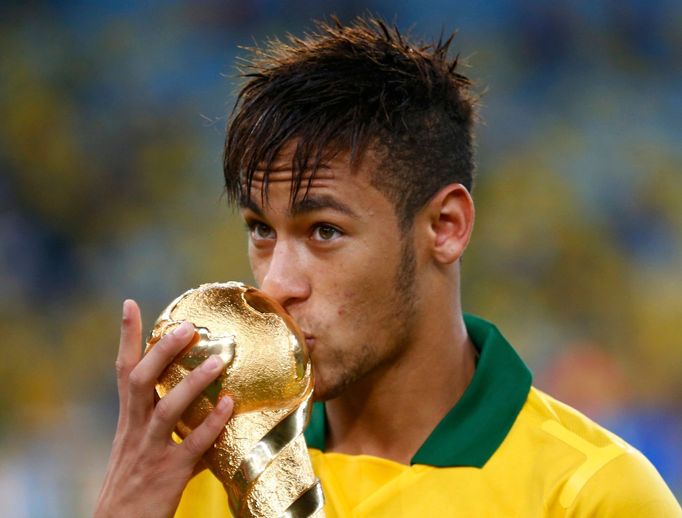 Brazil's Neymar kisses the trophy after winning their Confederations Cup final soccer match against Spain at the Estadio Maracana in Rio de Janeiro June 30, 2013. REUTERS