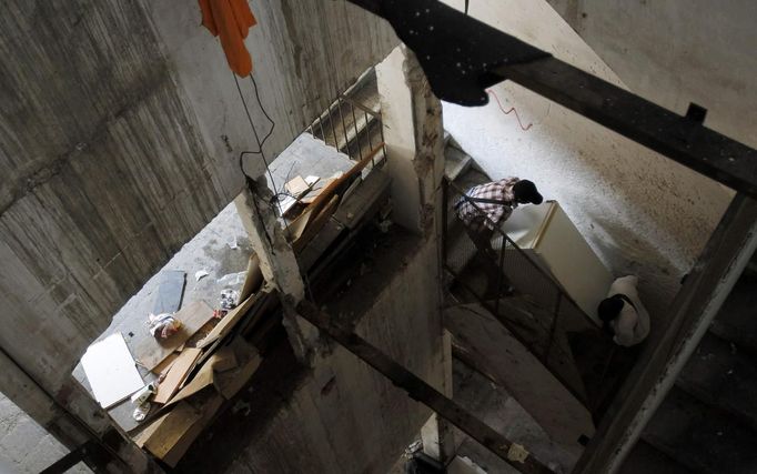 Squatters carry a fridge on the stairs of a building at an industrial complex in the Poble Nou neighbourhood of Barcelona July 16, 2012. The squatters said that a police order to evict them from the complex was postponed by a judge on Monday. REUTERS/Albert Gea (SPAIN - Tags: SOCIETY REAL ESTATE BUSINESS POVERTY) Published: Čec. 16, 2012, 5:08 odp.