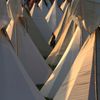 A festival goer makes his way through the tipis at Worthy Farm in Somerset, as the sun sets on the first day of the Glastonbury music festival