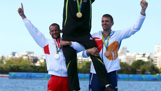 Novozélanďan Mahe Drysdale se vyšvihl na ramena zbývajících dvou medailistů v olympijském finále skifu. Ondřeje Synka (vpravo) porazil ještě Chorvat  Damir Martin.