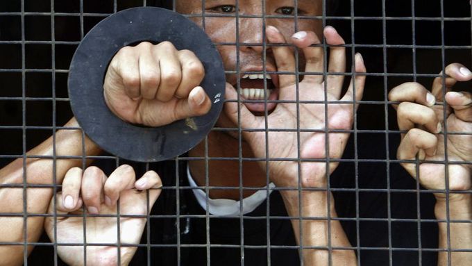 Zatčený Tibeťan křičí z policejní dodávky.