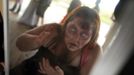 A zombie checks her make-up in a mirror before chasing runners on the "Run for Your Lives" 5K obstacle course race in Amesbury, Massachusetts May 5, 2012. Runners face man-made and natural obstacles on the course, while being chased by zombies, who try to take "health" flags off the runners belts. REUTERS/Brian Snyder (UNITED STATES) Published: Kvě. 5, 2012, 11:20 odp.