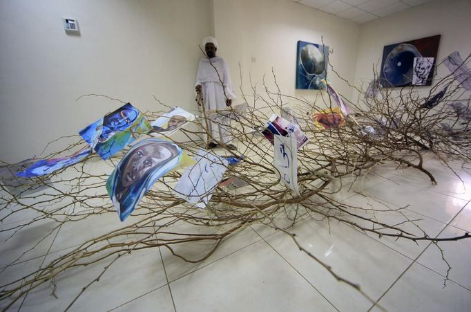 A sheikh from Khalwas of the Jabel Awlia district look at artwork from Greek/Swedish artist Martina Anagnostou during her exhibition, "Art in the Heart of a Clinic," in Khartoum