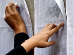 Lidé hledají svá jména v jedné z volebních místností v Caracasu