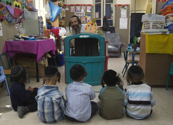 Ultra-Orthodox Jewish boys listen to their teacher at a kindergarten in Jerusalem's Mea Shearim neighbourhood May 24, 2012. The ultra-Orthodox Jews have gone from being a tiny minority in Israel's mostly secular society to its fastest-growing sector, now about 10 percent of the 7.8 million population. They are exempt from military duty in Israel but draft deferments and state subsidies for the ultra-Orthodox have become a divisive political issue in Israel, where the government must decide a new law by August to ensure more of them do military service. Picture taken May 24, 2012. REUTERS/Ronen Zvulun (JERUSALEM - Tags: RELIGION POLITICS EDUCATION MILITARY) ATTENTION EDITORS - PICTURE 10 OF 21 FOR PACKAGE "ISRAEL'S ULTRA-ORTHODOX". SEARCH "ULTRA-ORTHODOX" FOR ALL PICTURES Published: Čec. 6, 2012, 10:02 dop.