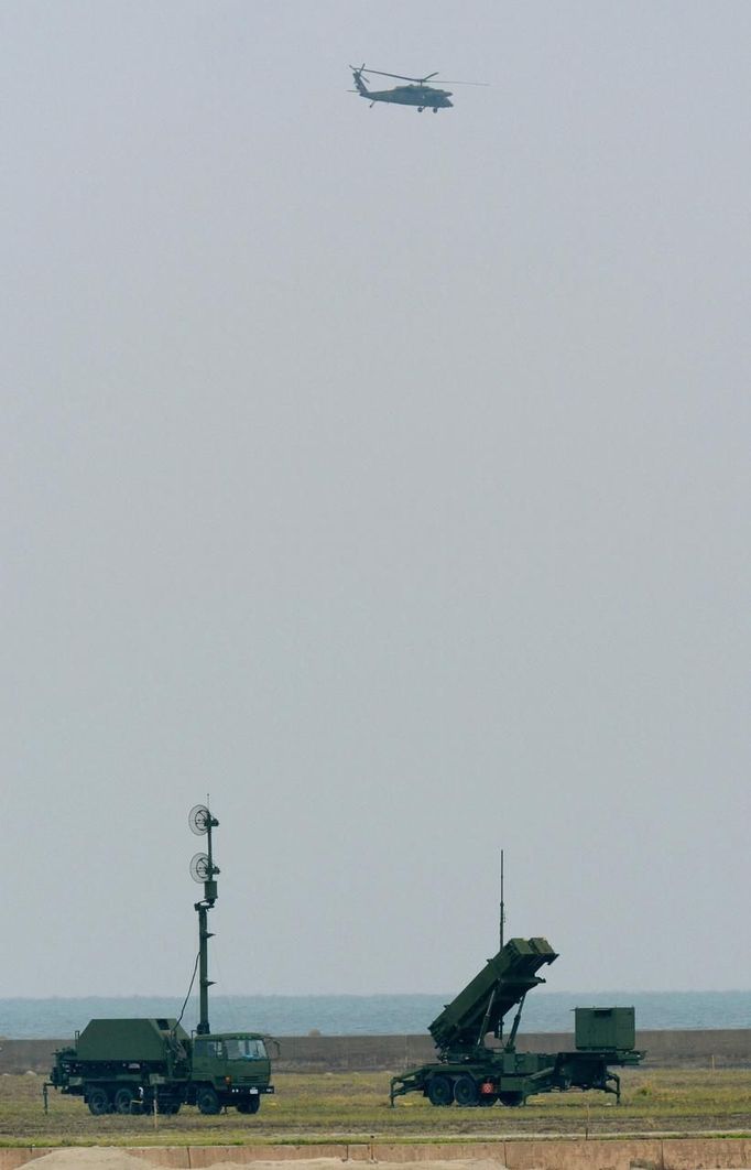 A helicopter of the Japan Self-Defence Forces flies over a Patriot Advanced Capability-3 (PAC-3) missiles unit after North Korea launched a rocket, in Ishigaki on Japan's southern island of Ishigaki Island, Okinawa prefecture, in this photo taken by Kyodo December 12, 2012. Isolated and impoverished North Korea launched its second long- range rocket of 2012 on Wednesday and may have finally succeeded in putting a satellite into space, the stated aim of what critics say is a disguised ballistic missile test. REUTERS/Kyodo (JAPAN - Tags: MILITARY POLITICS) FOR EDITORIAL USE ONLY. NOT FOR SALE FOR MARKETING OR ADVERTISING CAMPAIGNS. THIS IMAGE HAS BEEN SUPPLIED BY A THIRD PARTY. IT IS DISTRIBUTED, EXACTLY AS RECEIVED BY REUTERS, AS A SERVICE TO CLIENTS. MANDATORY CREDIT. JAPAN OUT. NO COMMERCIAL OR EDITORIAL SALES IN JAPAN. YES