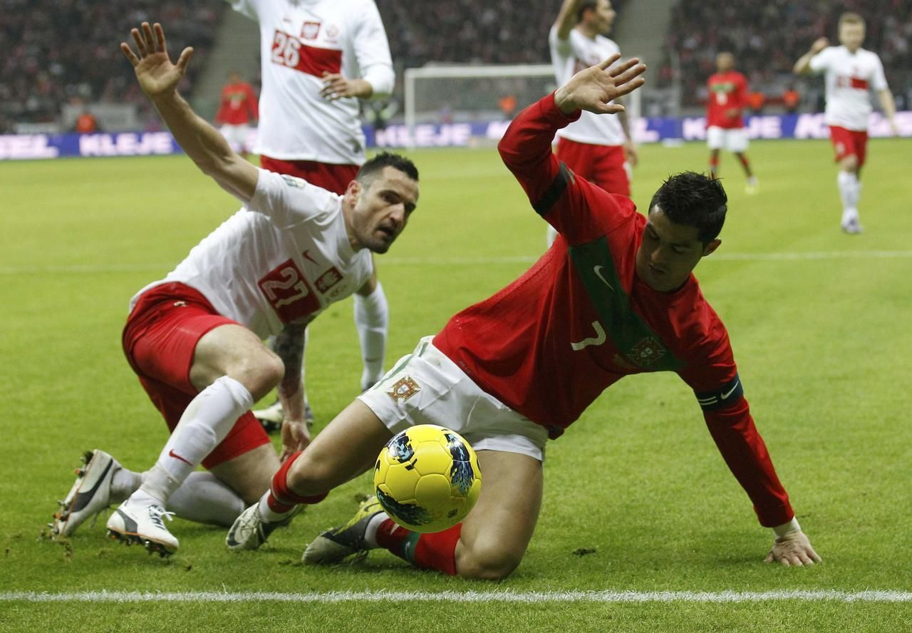 Polský fotbalista Wasilewski v souboji s Portugalcem Ronaldem