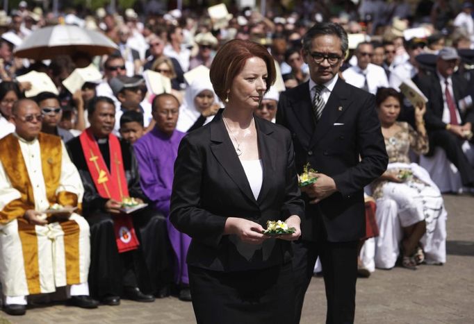 Australian Prime Minister Julia Gillard (L), along with Indonesia's Foreign Minister Marty Natalegawa, carry flowers during the commemoration service for the 10th anniversary of the Bali bombing in Garuda Wisnu Kencana (GWK) cultural park in Jimbaran, Bali October 12, 2012. Eighty-eight Australians were among the 202 people killed in the attacks on the Sari Club and Paddy's Bar at the popular tourist area of Kuta on October 12, 2002. REUTERS/Beawiharta (INDONESIA - Tags: ANNIVERSARY POLITICS) Published: Říj. 12, 2012, 3:56 dop.