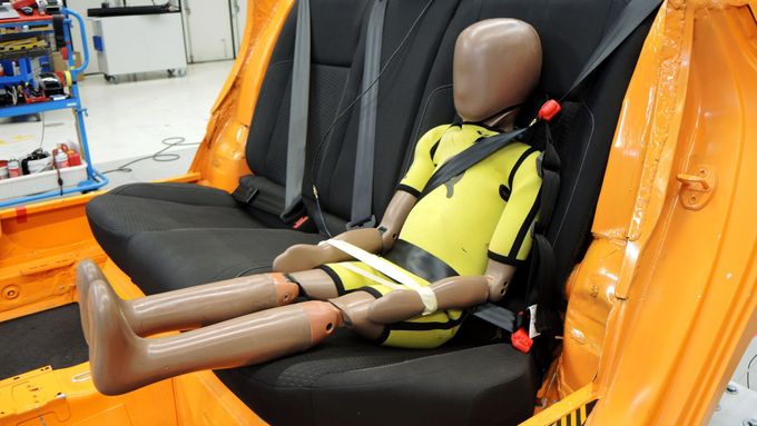 Figurína dítěte připoutaná s využitím speciálního nástavce bezpečnostního pásu.