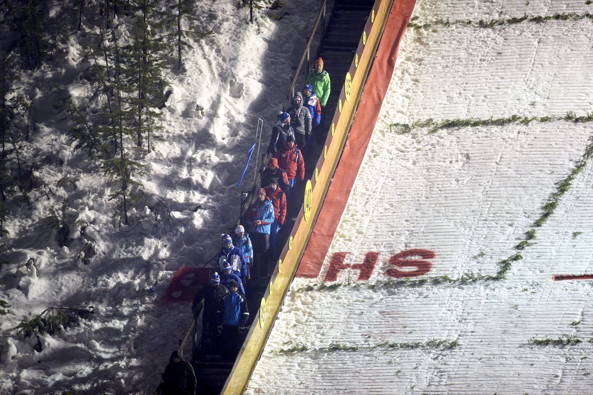 Coaches leave the ski jumping hill after the ski jumping competition in Ruka was canceled due to bad weather, at the FIS World Cup Ruka Nordic 2015 event