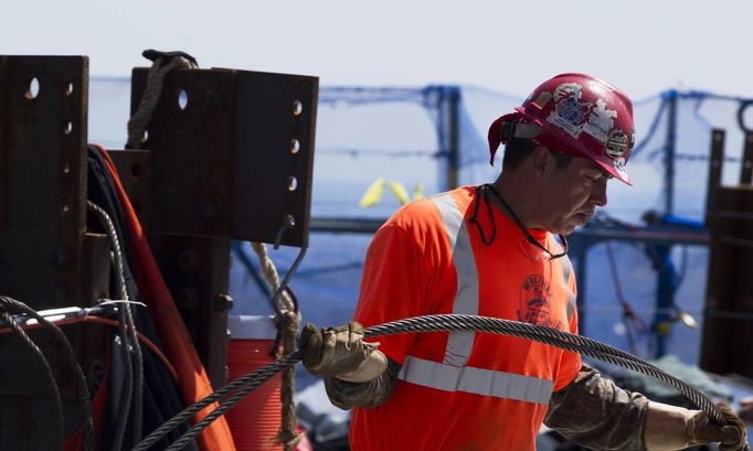 Iron worker Steven Cross carries steel cable across the 100th story of One World Trade Center in New York, April 30, 2012. The addition of iron columns to the 100th story pushed the height of One World Trade above that of the Empire State Building today. REUTERS/Lucas Jackson (UNITED STATES - Tags: CITYSPACE SOCIETY) Published: Dub. 30, 2012, 11:44 odp.