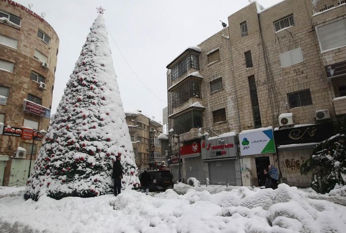 Palestinec před vánočním stromkem v Ramalláhu na Západním břehu Jordánu.