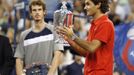 Roger Federer rozdává úsměvy s trofejí pro vítěze US Open, sleduje ho viditelně zklamaný Andy Murray.