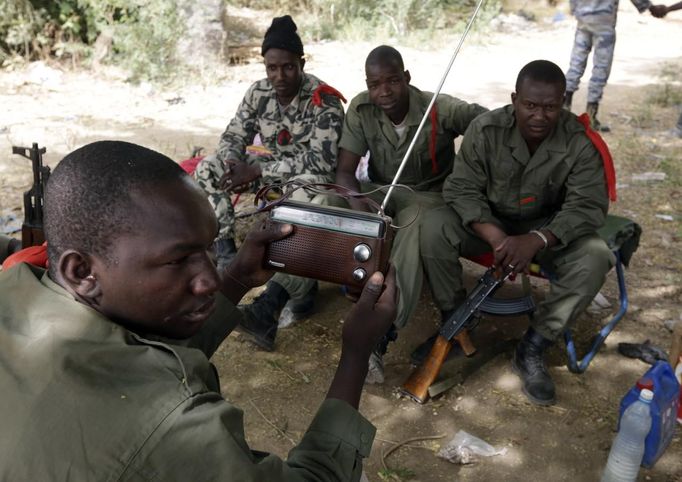 Malian soldiers listen to the news on a radio in the recently liberated town of Diabaly January 24, 2013. REUTERS/Eric Gaillard (MALI - Tags: CIVIL UNREST CONFLICT MILITARY POLITICS) Published: Led. 24, 2013, 6:16 odp.