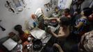 Luis Salgado (C, shirtless), nicknamed Chucho, makes coffee while surrounded by his family at his home in the village of Sagua La Grande in central Cuba, March 9, 2013. Chucho was granted a U.S. visa based on his father's status as legal resident in Texas, and he was reunited in Miami with his father, Jesus Salgado, who had escaped Cuba on a frail boat ten years earlier. The Salgados are among many Cubans taking advantage of Cuba's new travel policy in place since last January, which allows citizens to leave the country with just a passport and no need for much-hated exit visas required since 1961. Picture taken March 9, 2013. REUTERS/Desmond Boylan (CUBA - Tags: POLITICS SOCIETY) Published: Dub. 11, 2013, 1:01 odp.