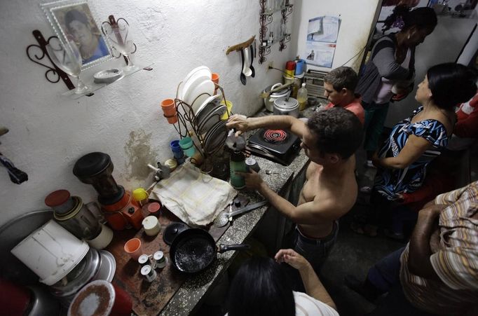 Luis Salgado (C, shirtless), nicknamed Chucho, makes coffee while surrounded by his family at his home in the village of Sagua La Grande in central Cuba, March 9, 2013. Chucho was granted a U.S. visa based on his father's status as legal resident in Texas, and he was reunited in Miami with his father, Jesus Salgado, who had escaped Cuba on a frail boat ten years earlier. The Salgados are among many Cubans taking advantage of Cuba's new travel policy in place since last January, which allows citizens to leave the country with just a passport and no need for much-hated exit visas required since 1961. Picture taken March 9, 2013. REUTERS/Desmond Boylan (CUBA - Tags: POLITICS SOCIETY) Published: Dub. 11, 2013, 1:01 odp.