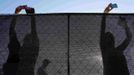 REFILE - QUALITY REPEAT Audience members take photographs over a fence as they arrive for a campaign rally with Republican presidential nominee Mitt Romney and Republican vice-presidential nominee U.S. Congressman Paul Ryan (R-WI) in Fishersville, Virginia October 4, 2012. REUTERS/Brian Snyder (UNITED STATES - Tags: POLITICS ELECTIONS USA PRESIDENTIAL ELECTION TPX IMAGES OF THE DAY) Published: Říj. 4, 2012, 10:48 odp.