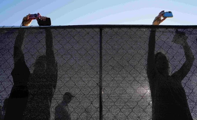 REFILE - QUALITY REPEAT Audience members take photographs over a fence as they arrive for a campaign rally with Republican presidential nominee Mitt Romney and Republican vice-presidential nominee U.S. Congressman Paul Ryan (R-WI) in Fishersville, Virginia October 4, 2012. REUTERS/Brian Snyder (UNITED STATES - Tags: POLITICS ELECTIONS USA PRESIDENTIAL ELECTION TPX IMAGES OF THE DAY) Published: Říj. 4, 2012, 10:48 odp.