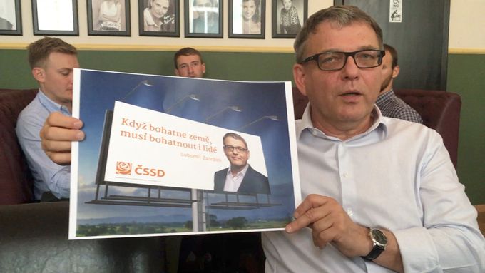 Lubomír Zaorálek ukazuje nový billboard na volební kampaň