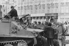Občané se snaží diskutovat s osádkou obrněného transportéru na Staroměstském náměstí. V pozadí poutač výstavy s nápisem Sovětské umění dvacátých let.