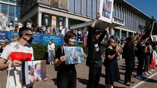 Demonstranti v Misku drží fotografie jako důkaz o policejní brutalitě vůči protestujícím.